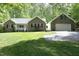 Charming brick home with a well-manicured lawn and attached two-car garage with fresh green foliage at 320 Delvin Lane Ln, Hillsborough, NC 27278