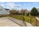 Backyard featuring a wooden deck overlooking a lush lawn with mature trees at 323 Windgate Dr, Clayton, NC 27527