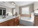 Bright bathroom with double sink vanity, soaking tub, and large window for natural light at 323 Windgate Dr, Clayton, NC 27527
