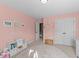 Bright bedroom featuring pink walls, a round rug, closet space, and decorations at 323 Windgate Dr, Clayton, NC 27527