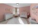 Charming Bedroom with pink walls, white crib, changing table, and light-filled windows at 323 Windgate Dr, Clayton, NC 27527