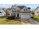 Charming two-story home with a well-manicured lawn and attached two car garage at 323 Windgate Dr, Clayton, NC 27527