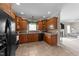 Kitchen featuring wooden cabinets, neutral countertops, tile flooring, and black appliances at 323 Windgate Dr, Clayton, NC 27527