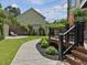 Inviting backyard featuring a wooden deck, a stamped concrete walkway, and lush landscaping, ideal for outdoor living at 3315 Denada Path, Durham, NC 27707