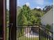 This balcony has a view of the fenced backyard and green trees at 3315 Denada Path, Durham, NC 27707