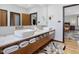 Bright bathroom features a dual vanity, marble countertop, wood floors, and a doorway leading to the bedroom at 3315 Denada Path, Durham, NC 27707