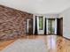 This primary bedroom features wood floors, a brick wall, and a door leading to a balcony at 3315 Denada Path, Durham, NC 27707