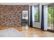 This primary bedroom features wood floors, a brick wall, and a bathroom en suite at 3315 Denada Path, Durham, NC 27707