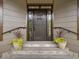Close-up of the front door entrance flanked by lovely flower arrangements and sconce lighting at 3315 Denada Path, Durham, NC 27707