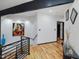 Bright hallway featuring hardwood floors, modern art, and stairway access to other levels at 3315 Denada Path, Durham, NC 27707
