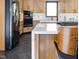 Close up of kitchen island featuring seating, modern appliances, and hardwood flooring at 3315 Denada Path, Durham, NC 27707