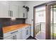 Laundry room featuring modern cabinets, wood countertop, and a sliding door to a balcony at 3315 Denada Path, Durham, NC 27707