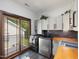 Well-lit laundry room features modern appliances, cabinets, counter space, and a sliding door to a balcony at 3315 Denada Path, Durham, NC 27707