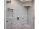 Modern gray tiled shower with rainfall showerhead, multiple jets, and convenient built-in shelving niche at 3315 Denada Path, Durham, NC 27707