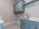 Stylish laundry room featuring blue cabinets, white countertops, gold hardware, and ample storage space at 40 Ridgeline Ct # 10, Pittsboro, NC 27312