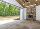 Covered stone patio featuring stone fireplace, ceiling fan, and backyard views at 40 Ridgeline Ct # 10, Pittsboro, NC 27312