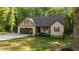 Charming single Gathering home showcasing a manicured lawn, rocking chairs, and attached garage at 4005 Colleen Way, Kittrell, NC 27544