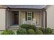 Covered front porch featuring rocking chairs, manicured shrubs, and a front door at 4005 Colleen Way, Kittrell, NC 27544