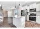 An interior view of a kitchen featuring a center island, stainless steel appliances, and white cabinets at 47 Peduncle St, Selma, NC 27576