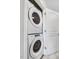 Modern white Whirlpool stacked washer and dryer inside an accessible laundry closet at 47 Peduncle St, Selma, NC 27576