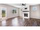 Bright living room featuring hardwood floors, a fireplace, and natural light from large windows at 47 Peduncle St, Selma, NC 27576