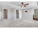 Spacious bedroom featuring a tray ceiling, ceiling fan, plush carpet and an ensuite bath and walk-in closet at 47 Peduncle St, Selma, NC 27576