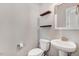 Powder room featuring a pedestal sink, toilet, decorative shelves, and modern fixtures at 47 Peduncle St, Selma, NC 27576
