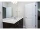 Bathroom vanity with a dark cabinet and light countertop, framed mirror and natural light at 49 Kathy Mae Ct, Angier, NC 27501
