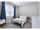 Comfortable bedroom with cozy rocking chair next to a window with blue curtains and a crib at 49 Kathy Mae Ct, Angier, NC 27501