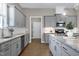 Bright kitchen features gray cabinets, granite countertops, stainless appliances, and hardwood floors at 49 Kathy Mae Ct, Angier, NC 27501