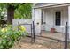 Cozy front porch with lattice and wrought iron fencing, surrounded by lush greenery at 511 E Maynard Ave, Durham, NC 27704
