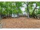 Secluded backyard featuring a white shed, mature trees, and ample space for outdoor activities at 5112 Wolcott Ct, Fuquay Varina, NC 27526