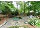 Backyard view featuring a tranquil pond with a waterfall, surrounded by lush landscaping at 5112 Wolcott Ct, Fuquay Varina, NC 27526