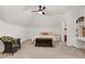 Cozy bedroom with seating area, ceiling fan, and large bed with decorative pillows at 5112 Wolcott Ct, Fuquay Varina, NC 27526