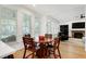Bright dining area with a round wooden table, chairs, and natural light streaming through large windows at 5112 Wolcott Ct, Fuquay Varina, NC 27526