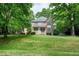 Inviting two-story brick home with covered front porch, surrounded by mature trees on a well-manicured lawn at 5112 Wolcott Ct, Fuquay Varina, NC 27526