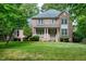 Charming two-story brick home with a covered porch and lush front lawn surrounded by mature trees at 5112 Wolcott Ct, Fuquay Varina, NC 27526