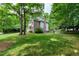 Backyard view of the brick home with a well-maintained lawn and surrounding trees at 5112 Wolcott Ct, Fuquay Varina, NC 27526