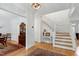 Bright foyer showcasing hardwood floors, elegant staircase, and decorative furnishings leading to the dining area at 5112 Wolcott Ct, Fuquay Varina, NC 27526