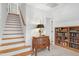 Hallway with stairs, lamp on chest, and built-in bookcase filled with books at 5112 Wolcott Ct, Fuquay Varina, NC 27526