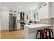 Modern kitchen featuring stainless steel appliances, white cabinets, stylish backsplash, and breakfast bar with seating at 5112 Wolcott Ct, Fuquay Varina, NC 27526