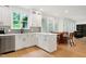 Spacious kitchen featuring white cabinets, stainless steel appliances, and a breakfast nook with ample sunlight at 5112 Wolcott Ct, Fuquay Varina, NC 27526