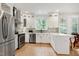 Well-lit kitchen showcasing stainless steel appliances, white cabinets, sleek countertops, and an efficient layout at 5112 Wolcott Ct, Fuquay Varina, NC 27526