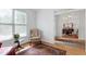 Bright sitting area with natural light, hardwood floors, a comfortable chair, and view of the dining room at 5112 Wolcott Ct, Fuquay Varina, NC 27526