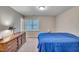 Bright bedroom featuring a dresser, window, neutral walls and blue bedspread at 5547 Sea Daisy Dr, Raleigh, NC 27606