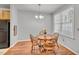Cozy dining room with wood table set for four under a chandelier and natural light at 5547 Sea Daisy Dr, Raleigh, NC 27606