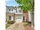 Charming townhome featuring a one car garage, brick accents, and mature tree at 5547 Sea Daisy Dr, Raleigh, NC 27606