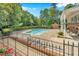 Beautiful community pool with mature landscaping and iron fencing at 5547 Sea Daisy Dr, Raleigh, NC 27606
