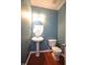 Powder room with pedestal sink, decorative mirror, and modern fixtures at 5927 Hourglass Ct, Raleigh, NC 27612