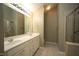 Bathroom featuring double sinks, large mirror, and tiled shower at 5927 Hourglass Ct, Raleigh, NC 27612